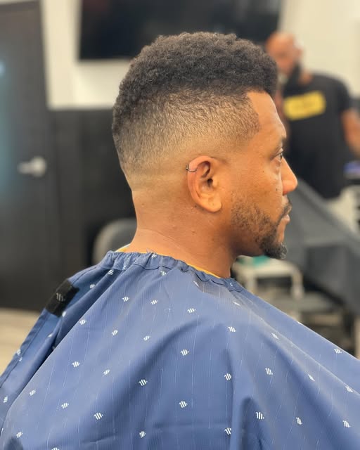 Side profile of a textured top with a blended fade and edged beard